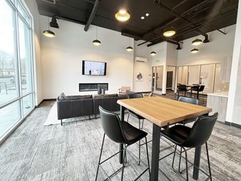 a communal area with a table and chairs and a living room with a tv at The Duo, University Place Washington